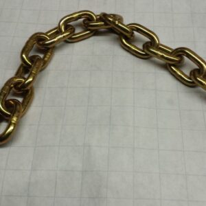 Gold metal chain links laid on a white graph-paper background.