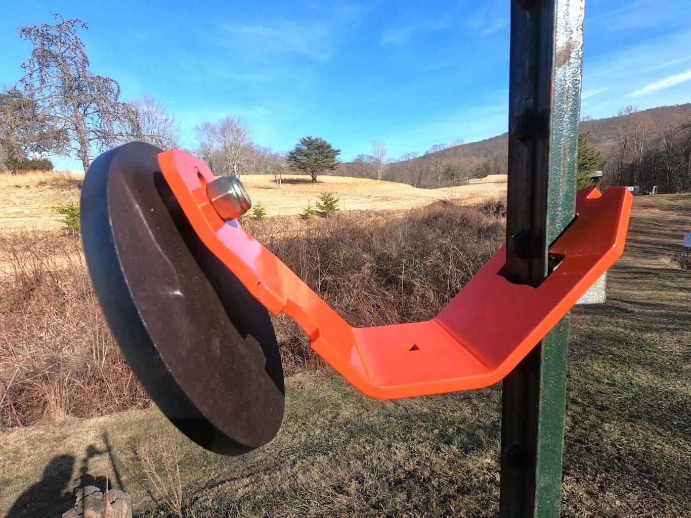Hang Fast Fail Safe T Post target hanger with 6 inch round AR500 target plate mounted on a T Post.