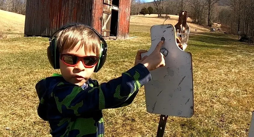 young shooting student inspecting target